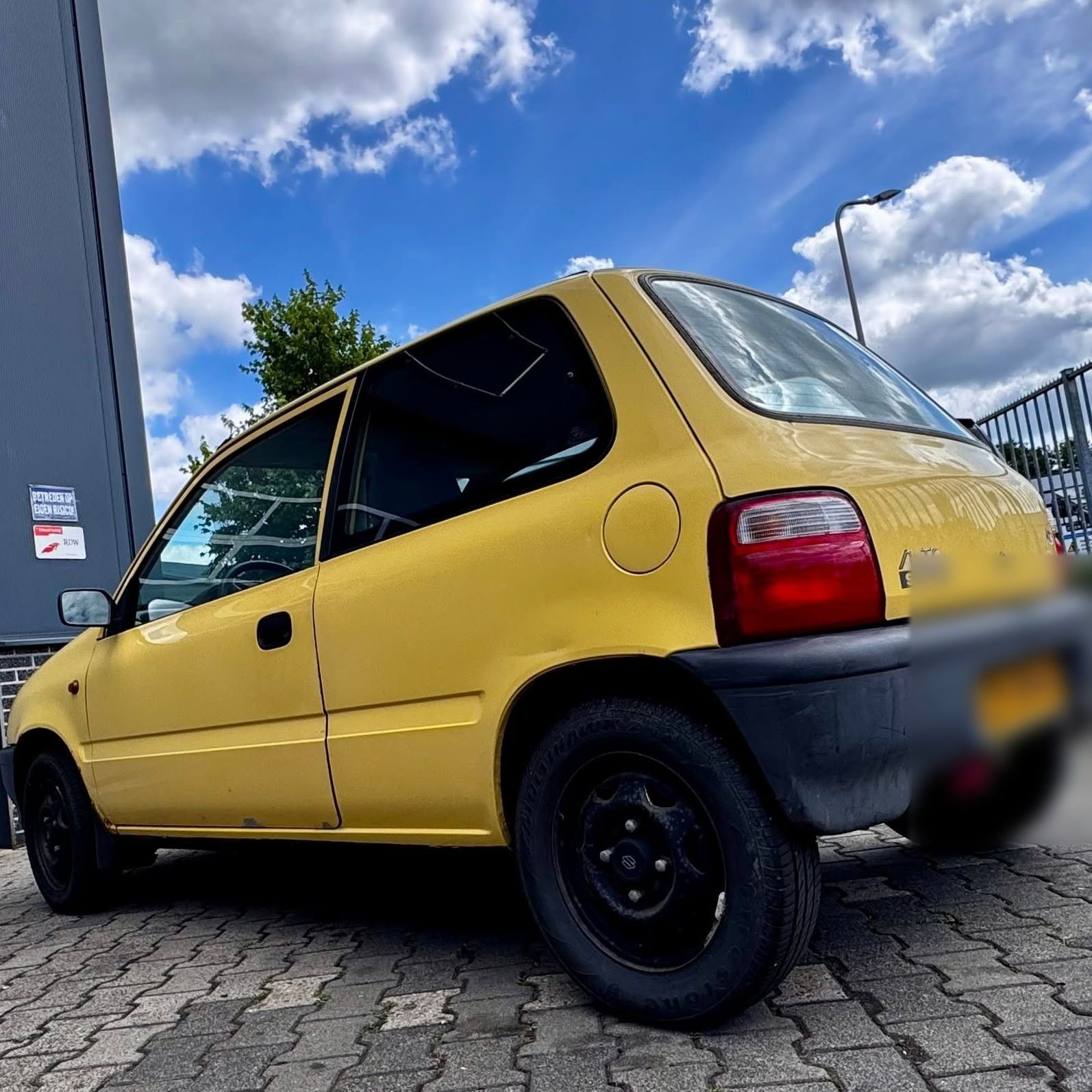 Gele Suzuki voor het pand van Fix2Drive